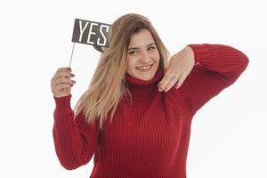 Woman holding engagement ring and sign saying YES photo