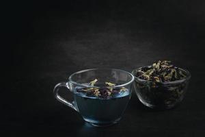 Butterfly pea flower tea in a clear glass on a black background. photo