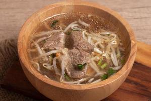 clear stewed pork soup in a wooden bowl photo