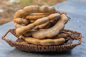 Tamarind in basket on the table background. fresh tamarind fruits photo