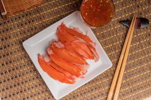 Boiled crab sticks with spicy and sour sauce photo