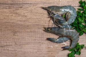 Fresh raw shrimp on wooden background photo