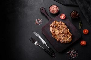 Delicious juicy grilled pork steak with spices and herbs photo