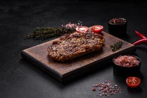 Delicious juicy grilled pork steak with spices and herbs photo