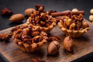 tarta dulce y sabrosa con nueces y miel sobre un fondo de hormigón oscuro foto