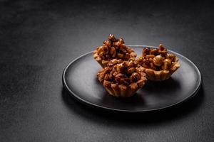 Sweet tasty tart with nuts and honey on a dark concrete background photo