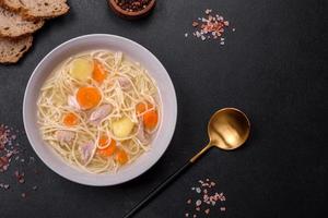 Delicious soup with noodles, chicken and carrots with spices and herbs photo