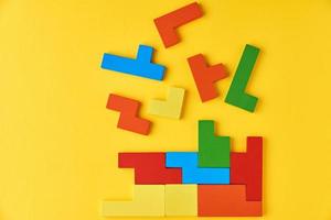 Different wooden blocks on yellow background photo