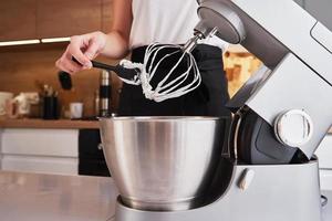 Woman using food processor to cooking in kitchen photo