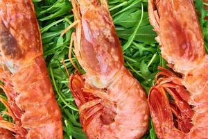 Red raw prawns, close up. Fresh shrimps with rucola. Seafood background photo
