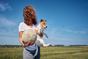 Friendship owner with pet. Woman have fun with her dog in summer day outdoors photo