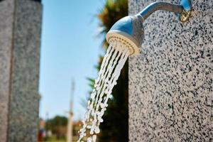 el agua sale de la ducha al aire libre foto