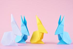 Paper colorful origami Esater rabbits on a pink background photo