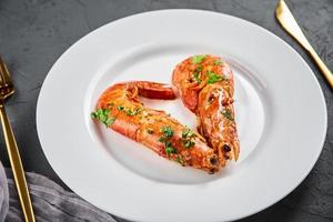 Two shrimps in shape of heart on the plate, top view. Love concept photo