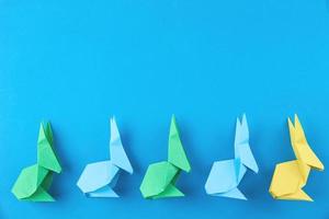 Paper colorful origami Esater rabbits on blue background photo