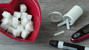 Sugar cubes in a heart shaped bowl. Diabetes testing kit video
