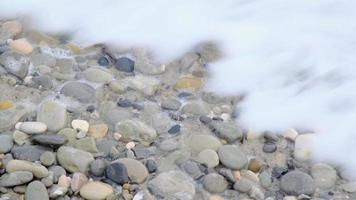 meereswellen am strand mit schaum und spritzern, nahaufnahme, gezeiten fließen am ufer. video