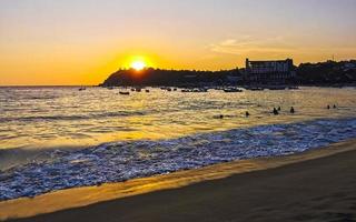 colorido atardecer dorado gran ola y playa puerto escondido mexico. foto