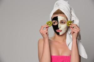 beautiful female model with black and white facial cosmetic mask photo