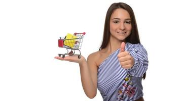 Credit card in a woman's hand and a small souvenir cart. Shopping, wholesale and retail trade, discounts, purchases on credit, credit history. photo