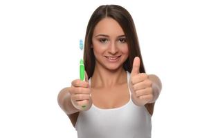 mujer joven sosteniendo un cepillo de dientes foto
