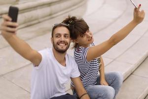 un par de turistas divirtiéndose caminando por las calles de la ciudad en vacaciones - amigos felices riéndose juntos en vacaciones - concepto de personas y vacaciones foto