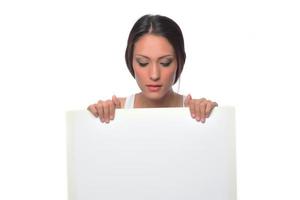 young smiling woman holding a blank sheet of paper for advertising photo