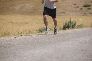 corredor de hombre deportivo corriendo en la meseta de la montaña en verano foto