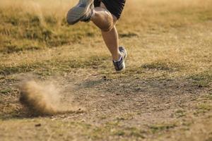 sporty man runner running on mountain plateau in summer photo