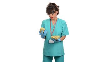 Female doctor holding a human brain model against white background photo