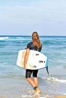 guapo surfista en la playa foto
