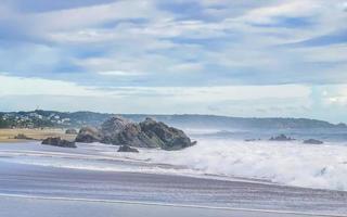 grandes olas para surfistas y rocas en la playa puerto escondido méxico. foto