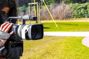 Woman girl filming in the park with a professional camera. photo