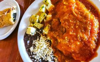 Mexican omelet with black beans potatoes nachos on white plate. photo