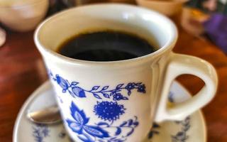 Blue white cup pot with black coffee wooden table Mexico. photo