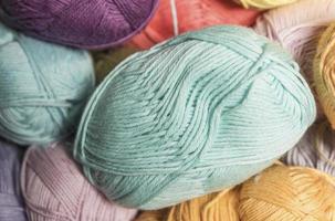 Colorful balls of wool on wooden table. Variety of yarn balls, view from above. photo