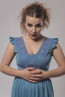 beautiful woman in blue dress posing in studio on gray background photo