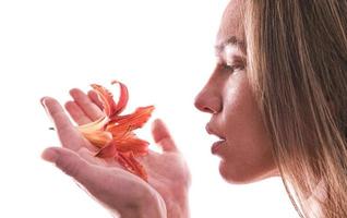 retrato artístico de una mujer sosteniendo una flor de lirio. concepto de belleza. aislado sobre fondo blanco foto