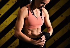 Close-up of a woman doing boxing bandages in a fighting cage photo