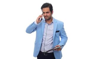Arab businessman talking on his cellphone and holding paperwork on clipboard. isolated on white photo