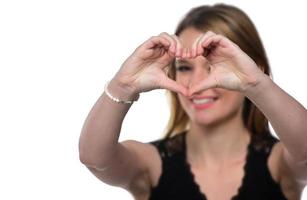 Portrait of a young woman making a heart gesture with her hands photo