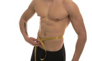 male model with great body measuring his body with measuring tape photo