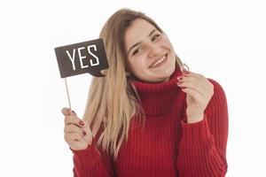 Woman holding engagement ring and sign saying YES photo