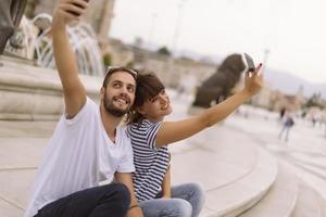 un par de turistas divirtiéndose caminando por las calles de la ciudad en vacaciones - amigos felices riéndose juntos en vacaciones - concepto de personas y vacaciones foto