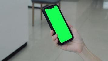 Green screen, smartphone green screen in hand, Use green screen for copy space closeup. Chroma key mock-up on smartphone in hand. Woman holds mobile phone green screen video