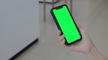 groen scherm, smartphone groen scherm in hand, gebruik groen scherm voor kopiëren ruimte detailopname. chroma sleutel mock-up Aan smartphone in hand. vrouw houdt mobiel telefoon groen scherm video