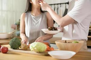 una joven pareja asiática disfruta cocinando con ingredientes saludables de verduras y frutas en la cocina en casa, concepto de estilo de vida de bienestar saludable.