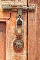 Brown wooden door has a key and a lock and a handle for locking the door to prevent thieves and thieves from stealing your belongings and valuables. It is an ancient wooden door photo