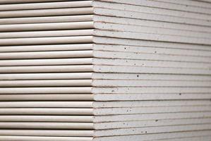 Drywall standard gypsum panels, wallboards plasterboard stacked in hardware store closeup photo