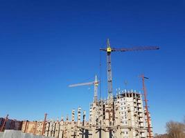 muchos edificios de gran altura y grúas en construcción bajo el cielo azul foto